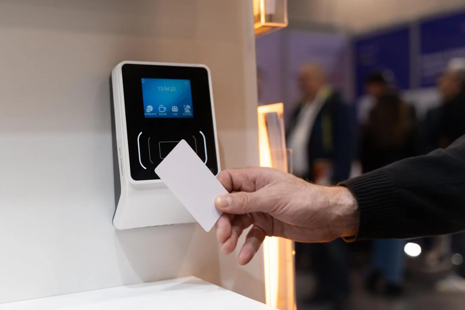 Badgeuse eTSmile fixée au mur, un collaborateur présente sa carte devant le lecteur